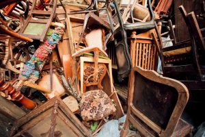 Vintage wooden furniture in trash warehouse of antique market. Retro background